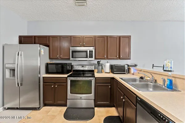 a kitchen with a sink appliances and cabinets