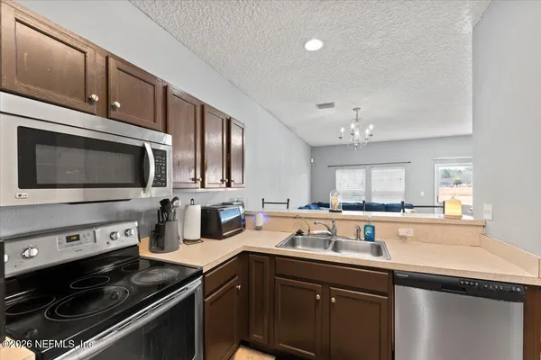 a kitchen with stainless steel appliances a sink stove and microwave