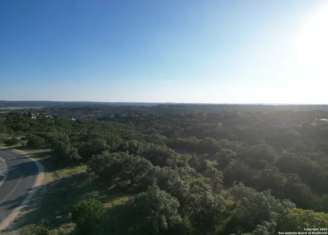 an aerial view of house with yard and mountain view in back