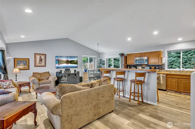 a living room with furniture a large window and kitchen view