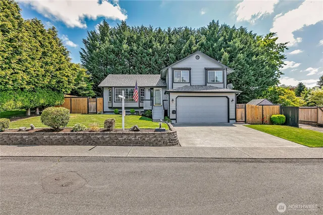 a front view of a house with a garden and garage
