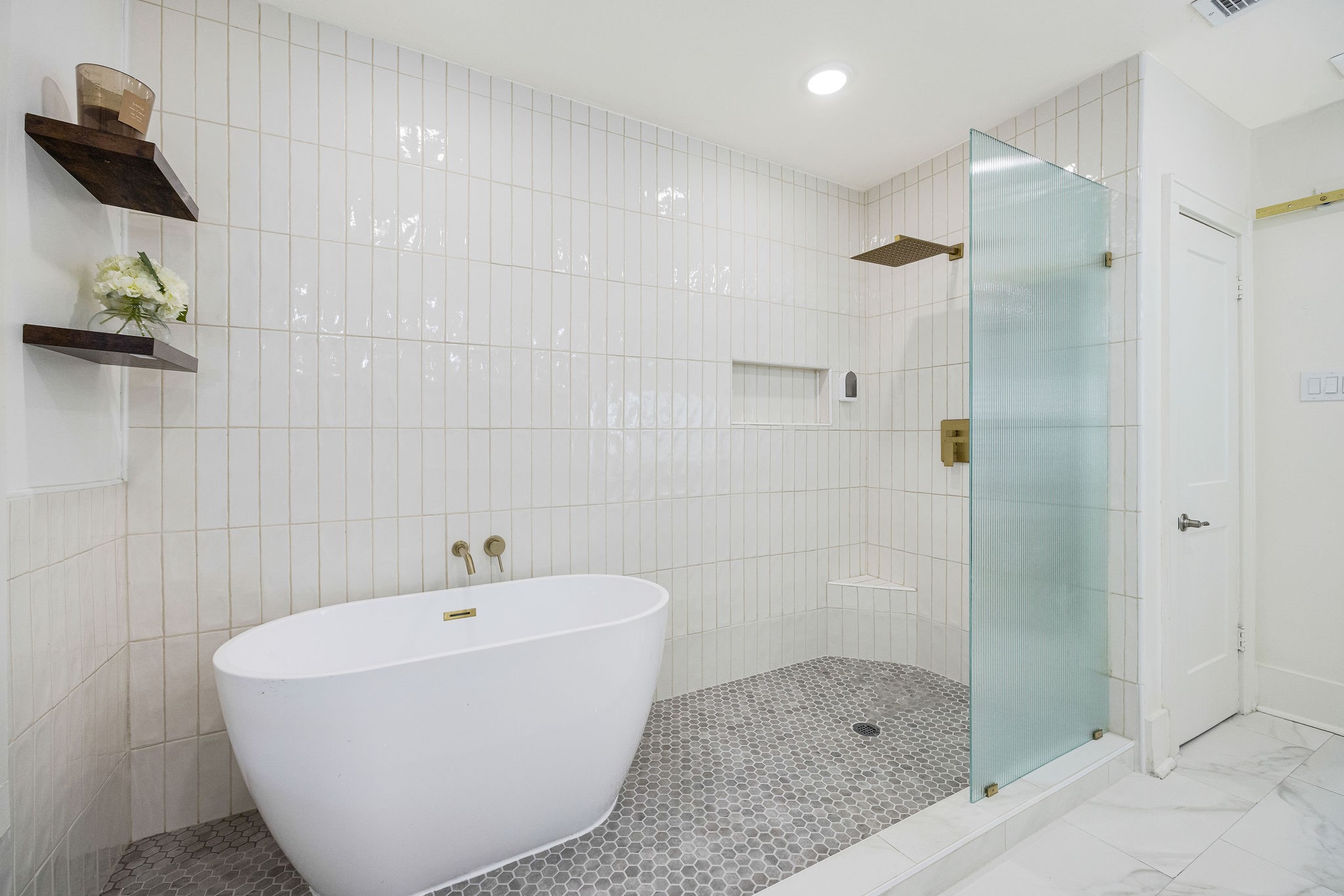2613 Wichita Street Houston, TX 77004 - Photo 21 of 25 Fully renovated primary bathroom featuring dual vanities, designer finishes, a freestanding soaking tub, and an oversized walk-in shower.