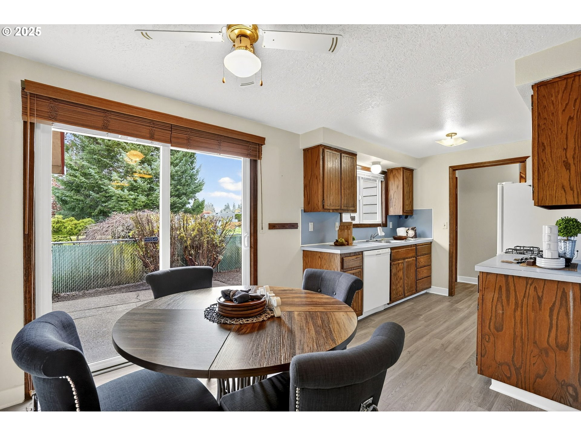 1427 Southeast Wendy Avenue Gresham, OR 97080 - Photo 13 of 35 a open kitchen with stainless steel appliances granite countertop a stove a refrigerator a sink dishwasher a dining table and chairs with wooden floor
