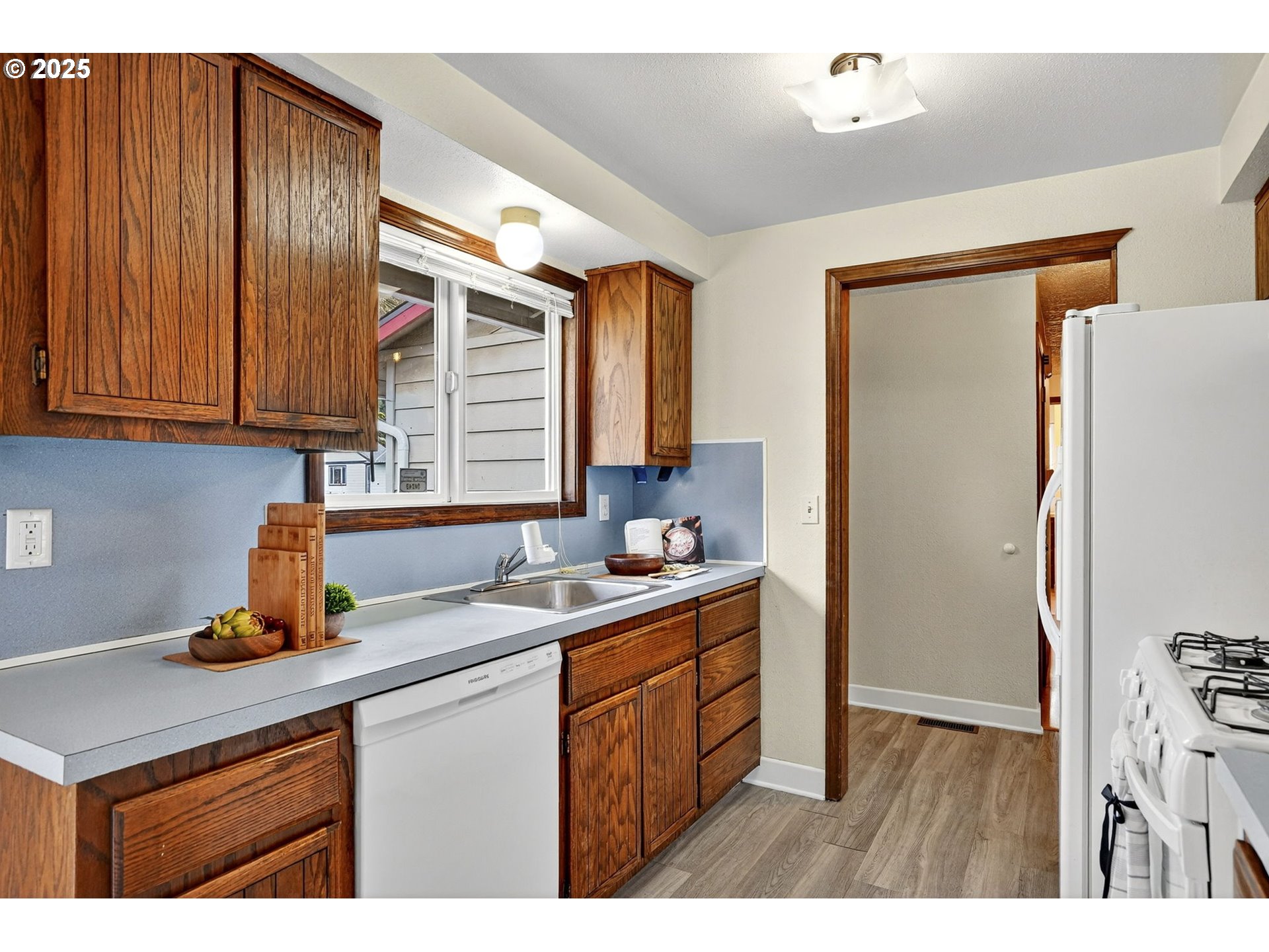 1427 Southeast Wendy Avenue Gresham, OR 97080 - Photo 15 of 35 a kitchen with a sink refrigerator and cabinets