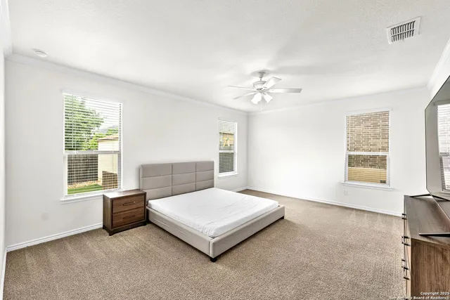 a spacious bedroom with a bed and a window