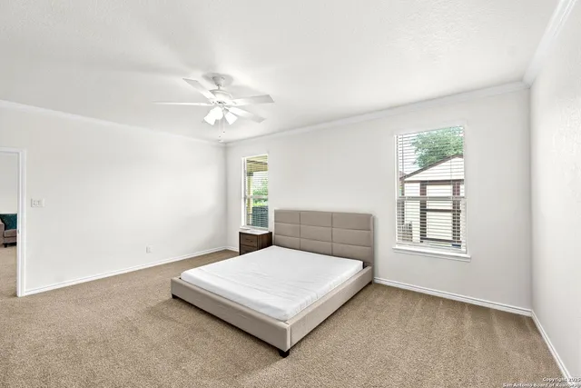 an empty room with windows and ceiling fan