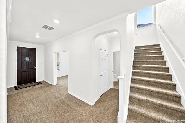 a view of an empty room with stairs and stairs