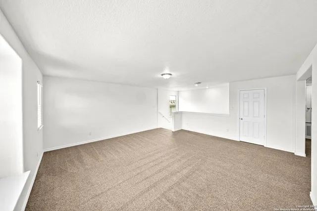 a view of an empty room with a kitchen