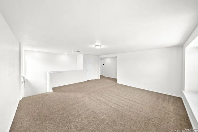 a view of an empty room with a kitchen