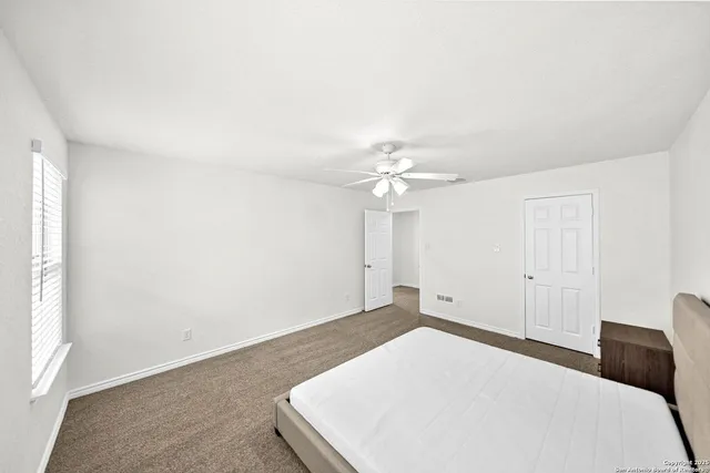 a bedroom with a bed and a ceiling fan