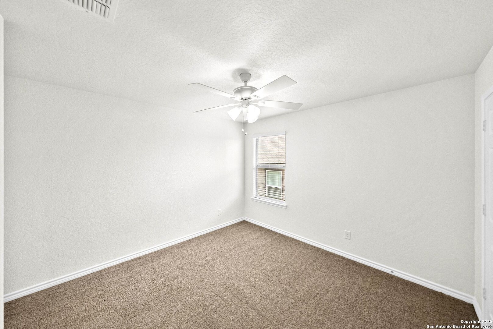 7621 Lorca Boerne, TX 78015 - Photo 39 of 46 an empty room with a chandelier fan and windows