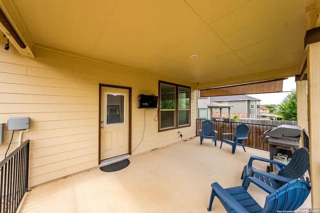 a view of a patio with couches chairs potted plants and floor to ceiling window