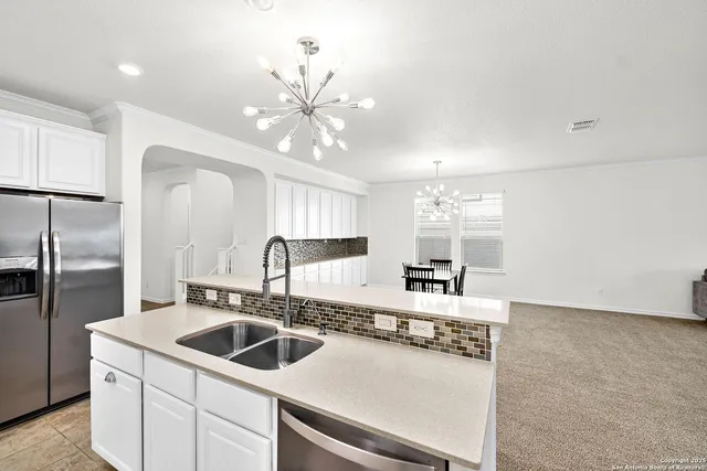 a kitchen with a sink a counter top space cabinets and stainless steel appliances