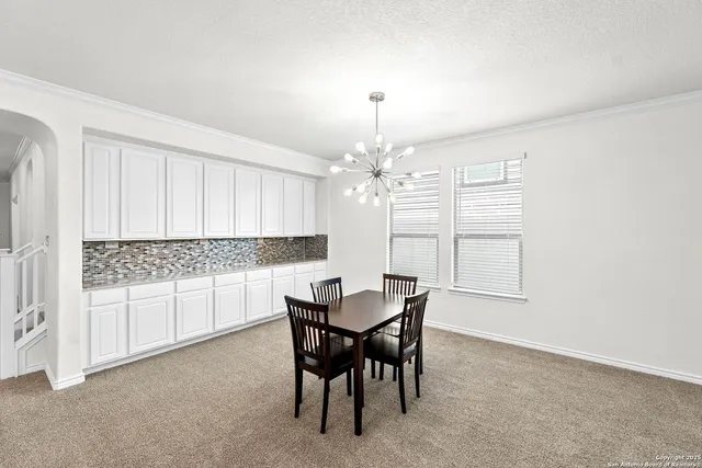 a view of a dining room with furniture and chandelier