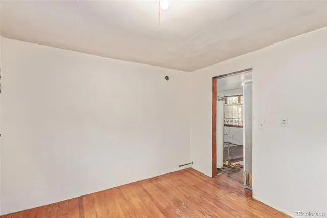 an empty room with wooden floor and closet