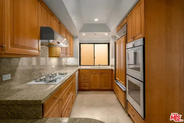 a kitchen with stainless steel appliances granite countertop a stove and a refrigerator