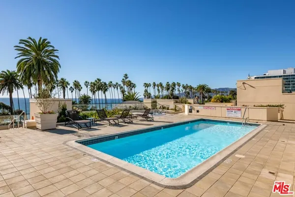 a view of swimming pool with outdoor seating and plants