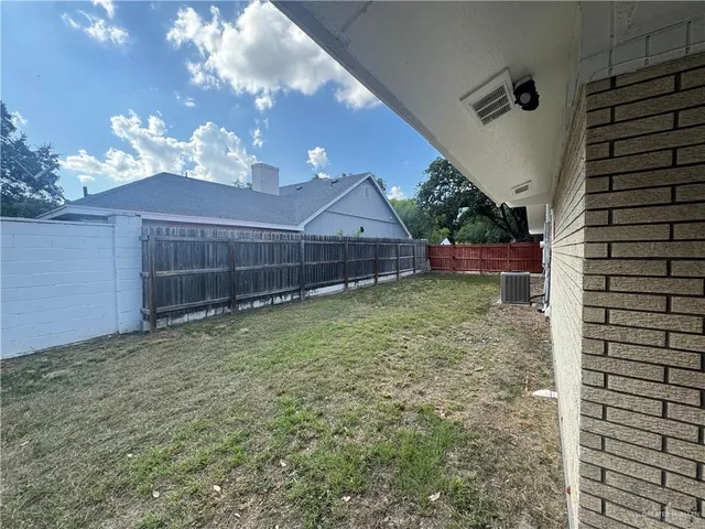 a view of a backyard with potted plants and large tree