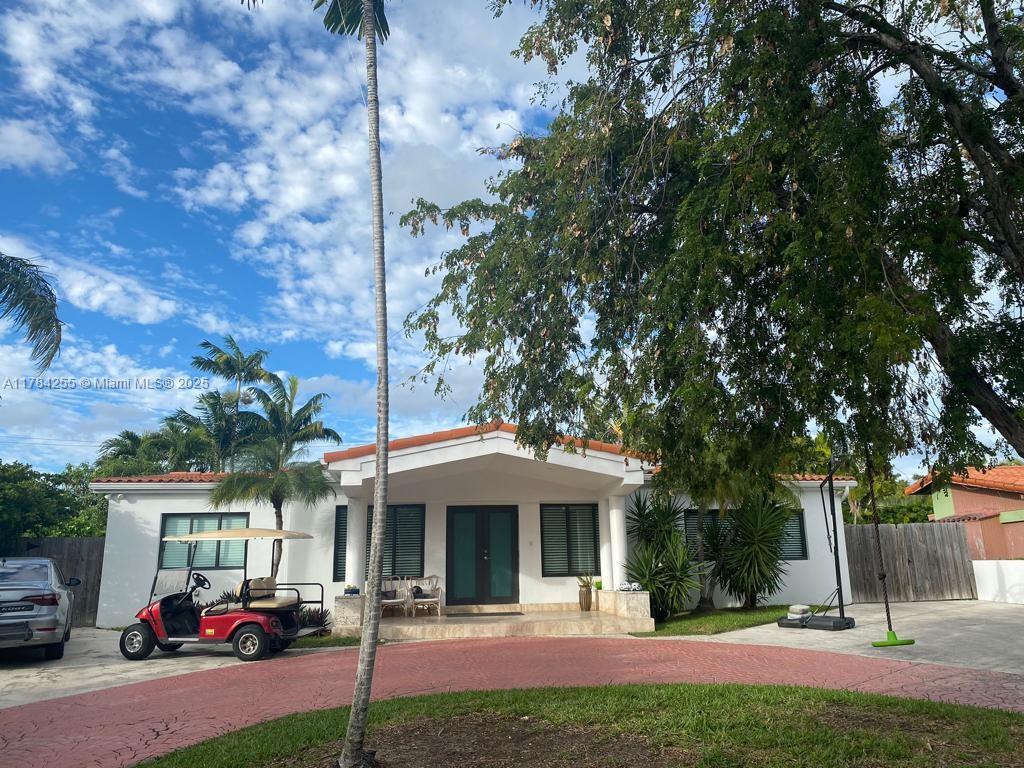 Tropical Isle Homes Key Biscayne, FL 33149 - Photo 13 of 38 a front view of a house with a yard and table and chairs
