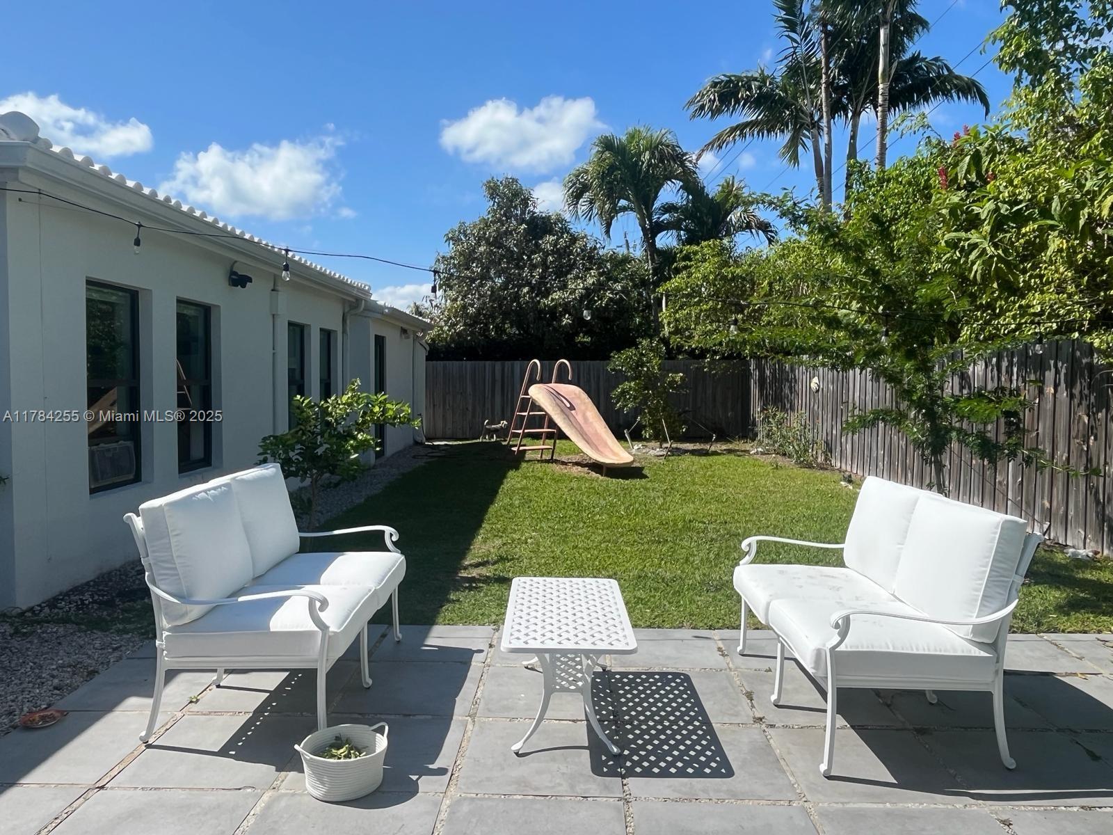 Tropical Isle Homes Key Biscayne, FL 33149 - Photo 17 of 38 a view of a chair and table in backyard of the house