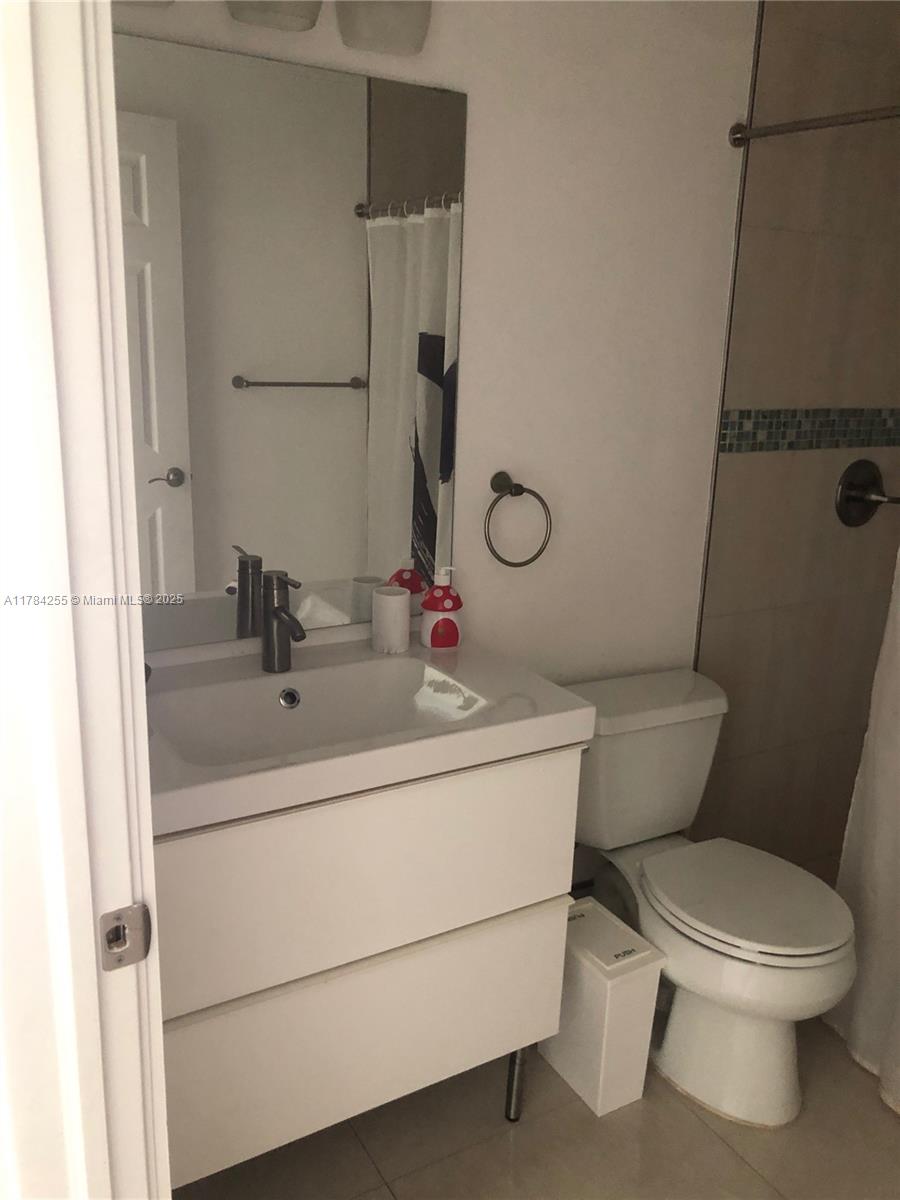 Tropical Isle Homes Key Biscayne, FL 33149 - Photo 27 of 38 a bathroom with a toilet sink and mirror