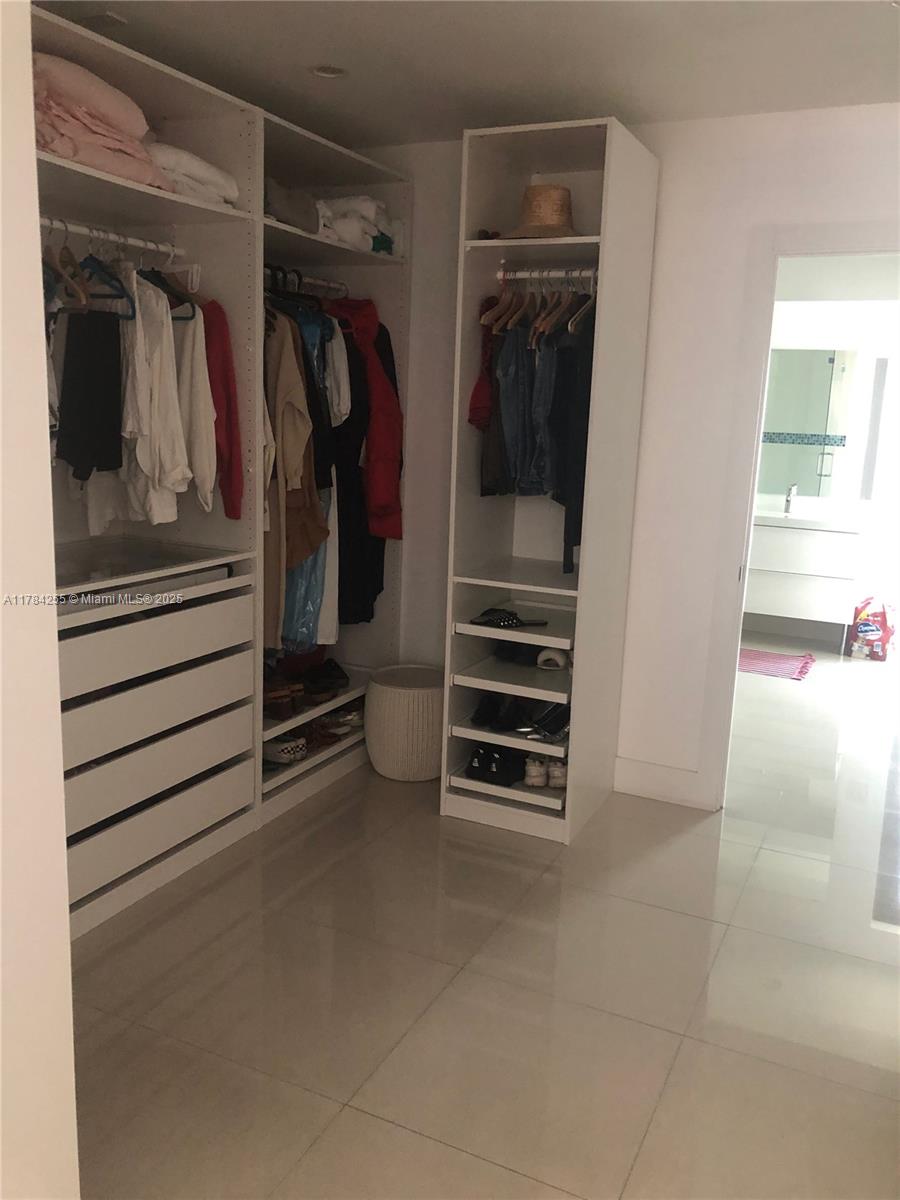 Tropical Isle Homes Key Biscayne, FL 33149 - Photo 29 of 38 a view of walk in closet with clothes and shoes