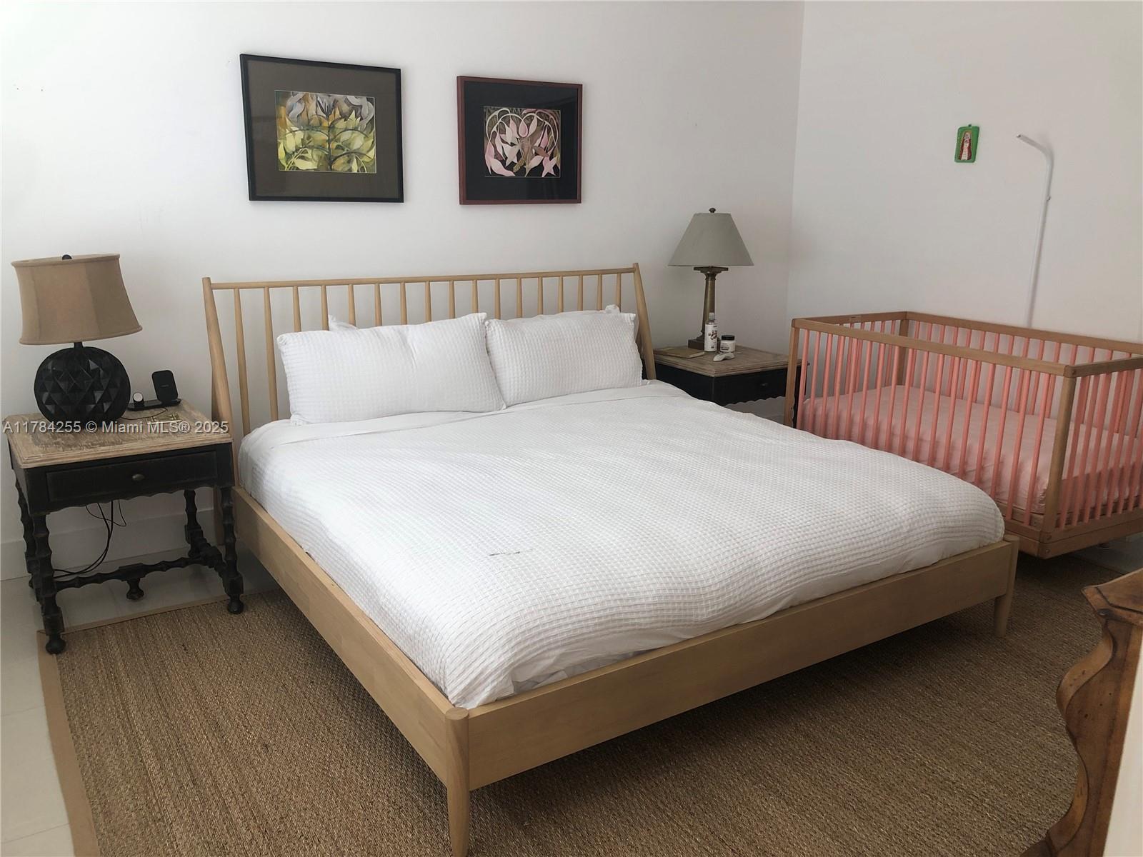 Tropical Isle Homes Key Biscayne, FL 33149 - Photo 30 of 38 a large bed sitting in a bedroom next to a lamp