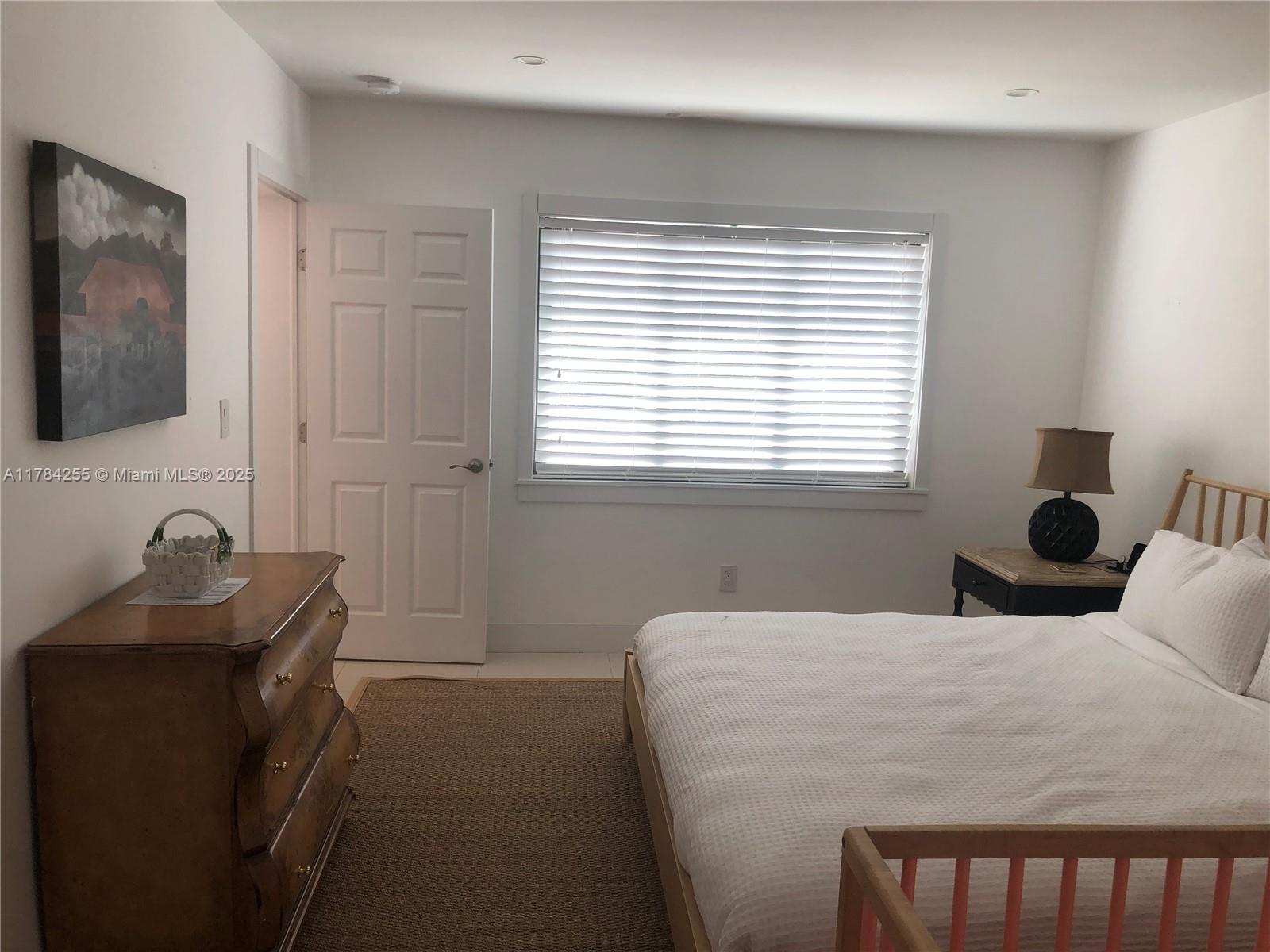 Tropical Isle Homes Key Biscayne, FL 33149 - Photo 31 of 38 a bedroom with a bed and a window