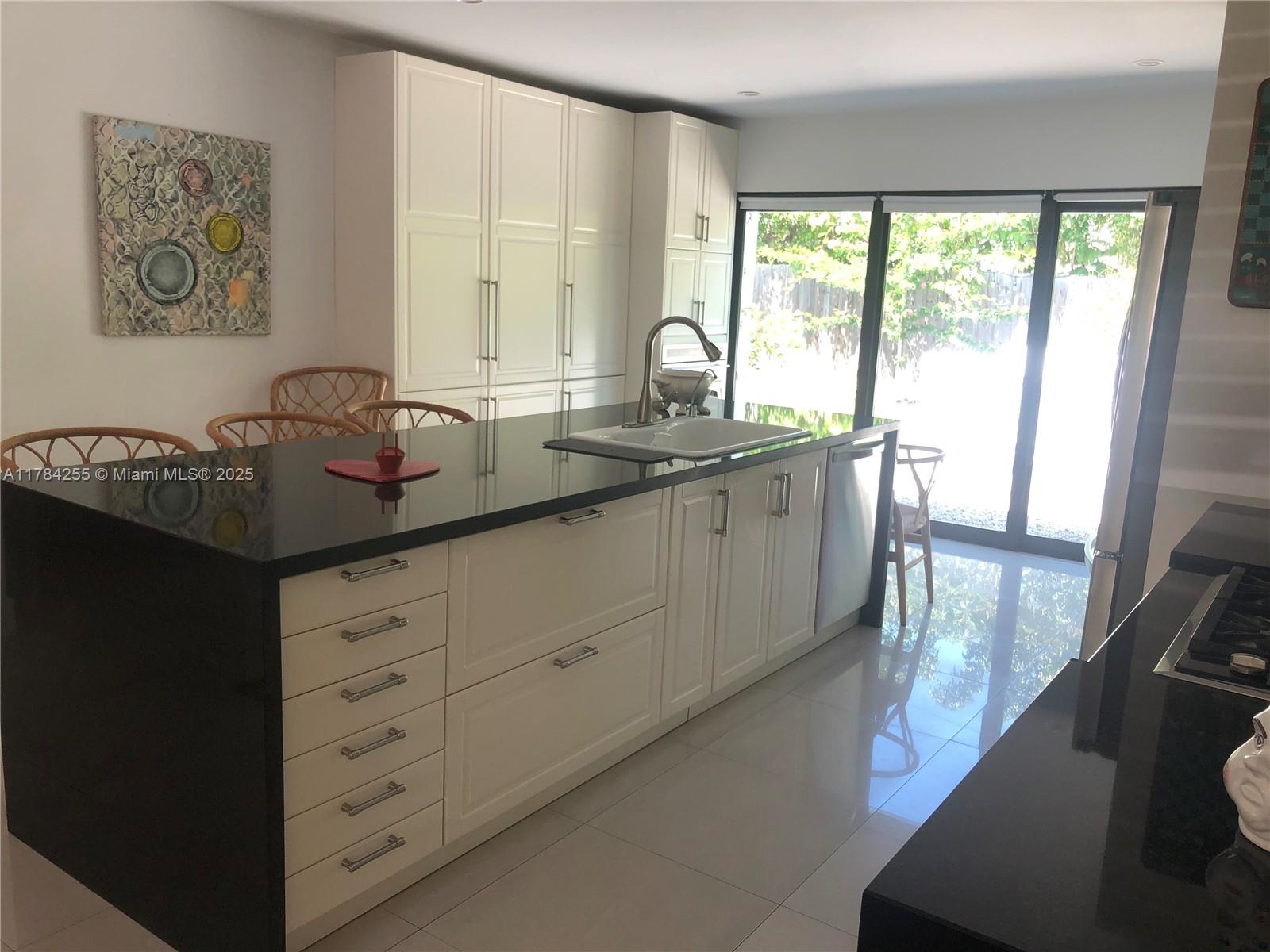 Tropical Isle Homes Key Biscayne, FL 33149 - Photo 34 of 38 a kitchen with sink a window and cabinets