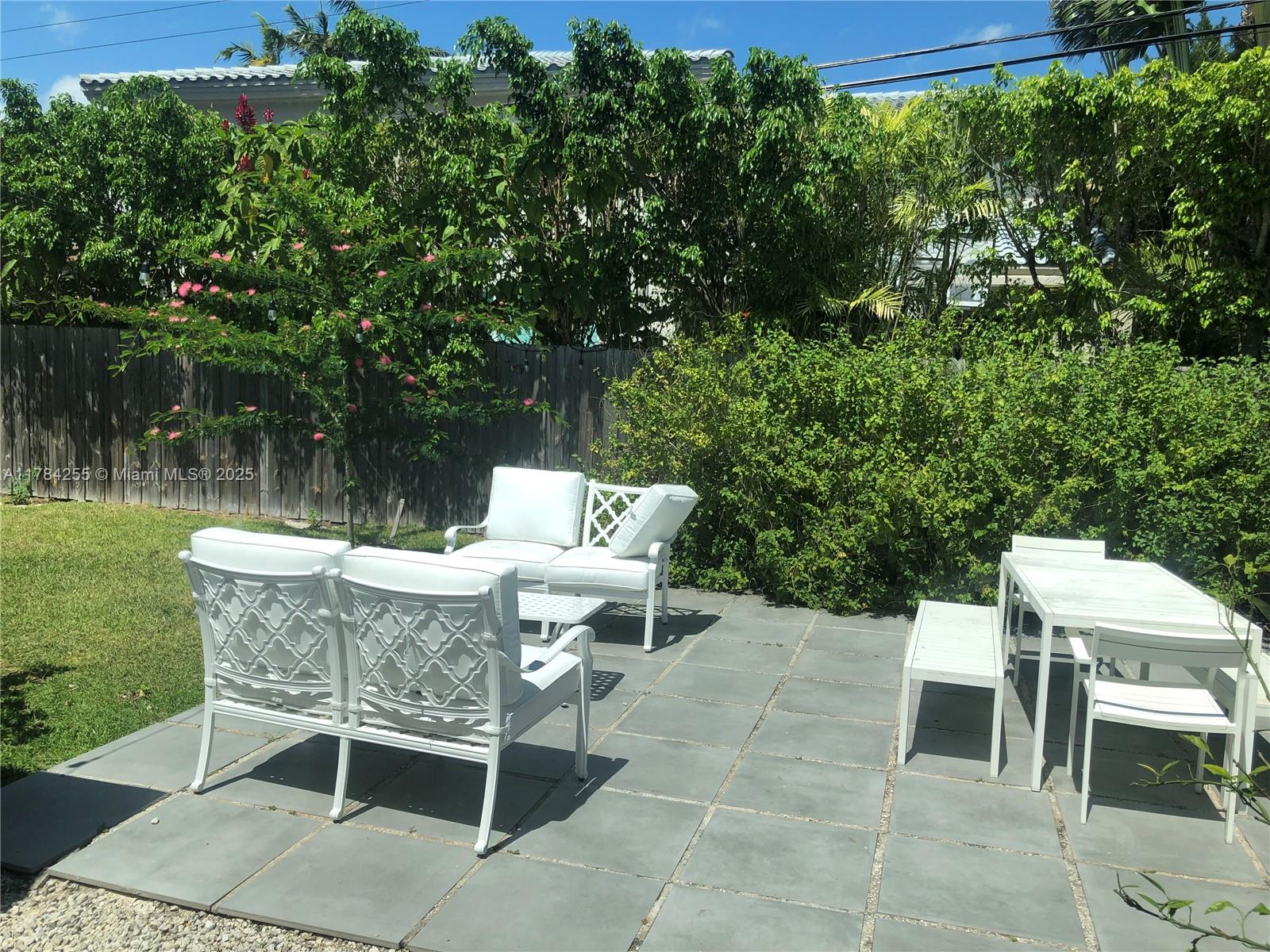 Tropical Isle Homes Key Biscayne, FL 33149 - Photo 35 of 38 a view of a patio with table and chairs and potted plants