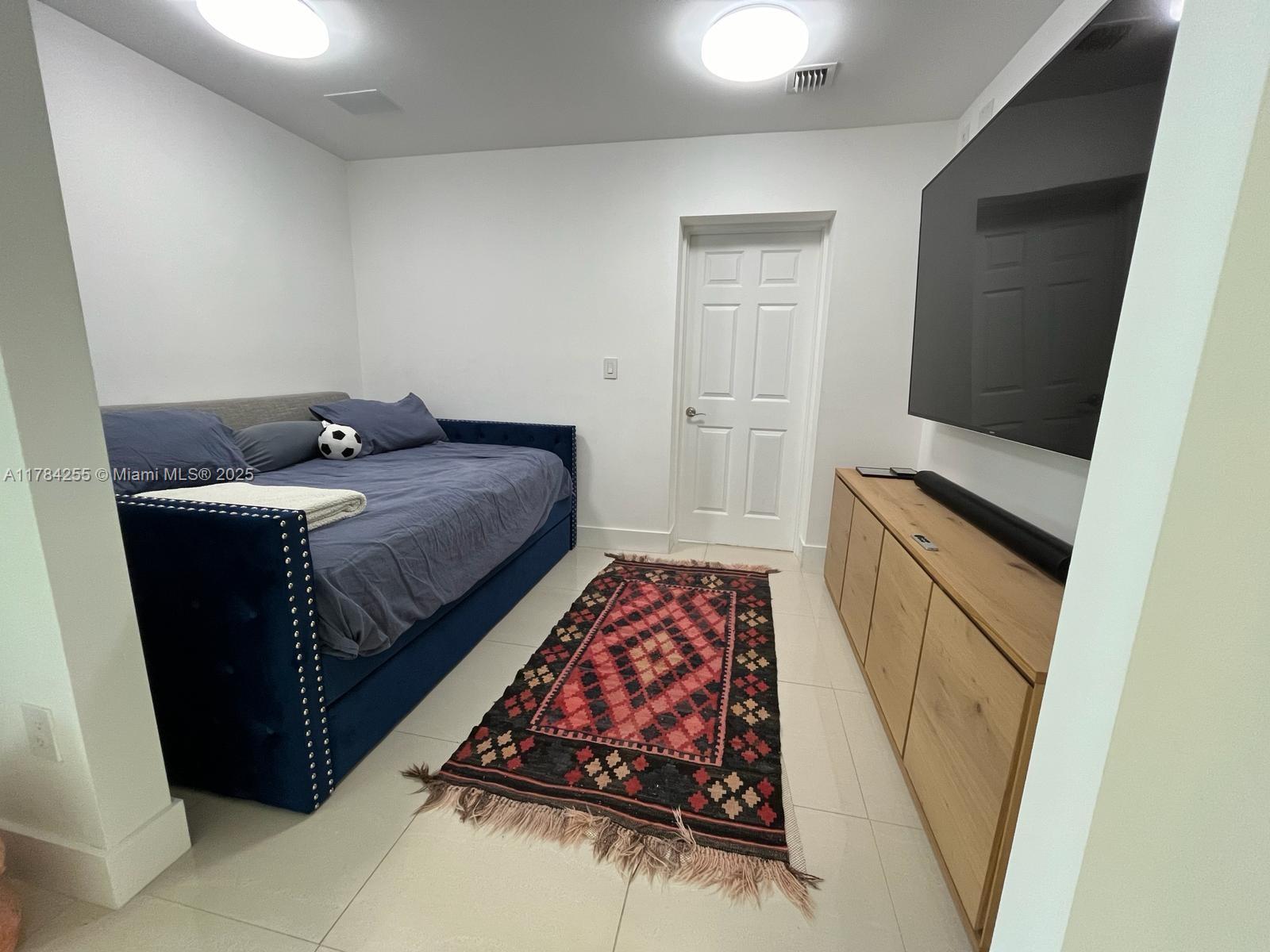 Tropical Isle Homes Key Biscayne, FL 33149 - Photo 9 of 38 a bedroom with a bed and wooden floor