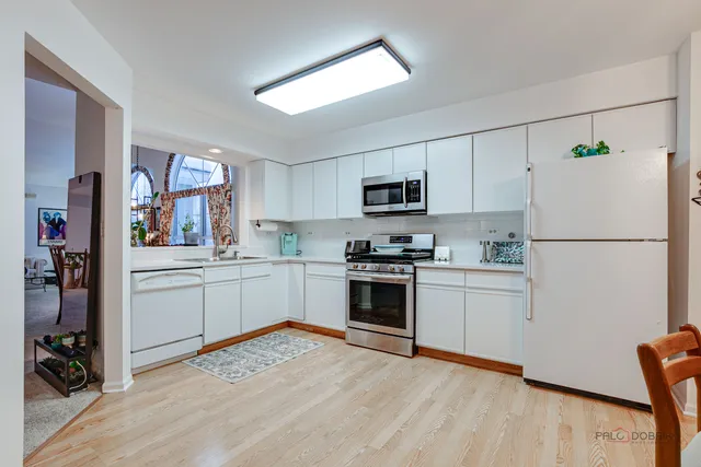 a kitchen with white cabinets and stainless steel appliances