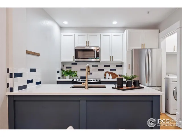 a kitchen with kitchen island a sink stainless steel appliances and cabinets