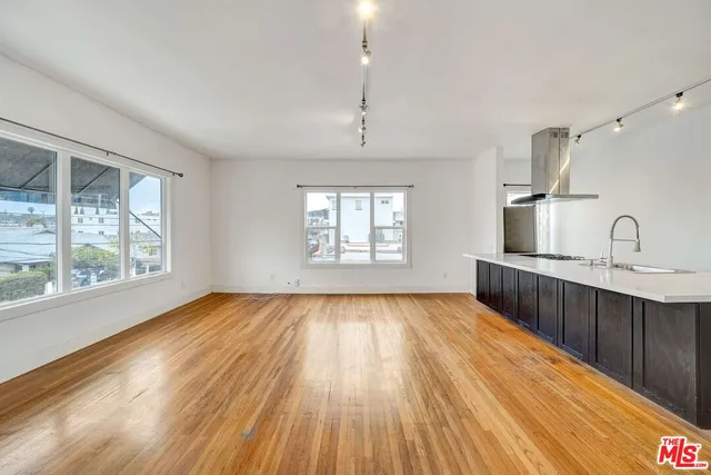 a view of kitchen with stainless steel appliances wooden floor and granite top