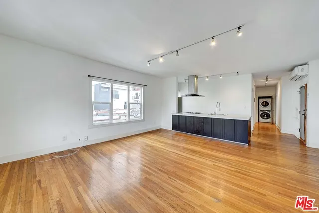 a view of empty room with wooden floor and window