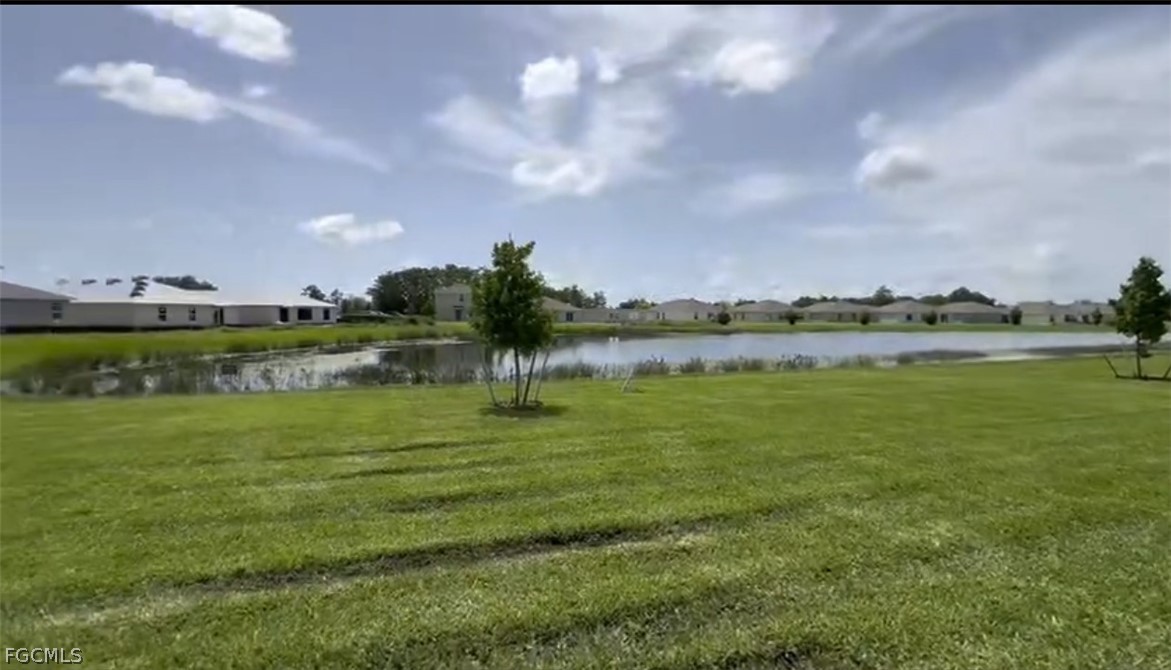 12312 Amber Waves Road Lehigh Acres, FL 33974 - Photo 21 of 33 a view of a lake with houses in the back