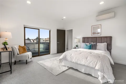 a bedroom with a bed and large windows