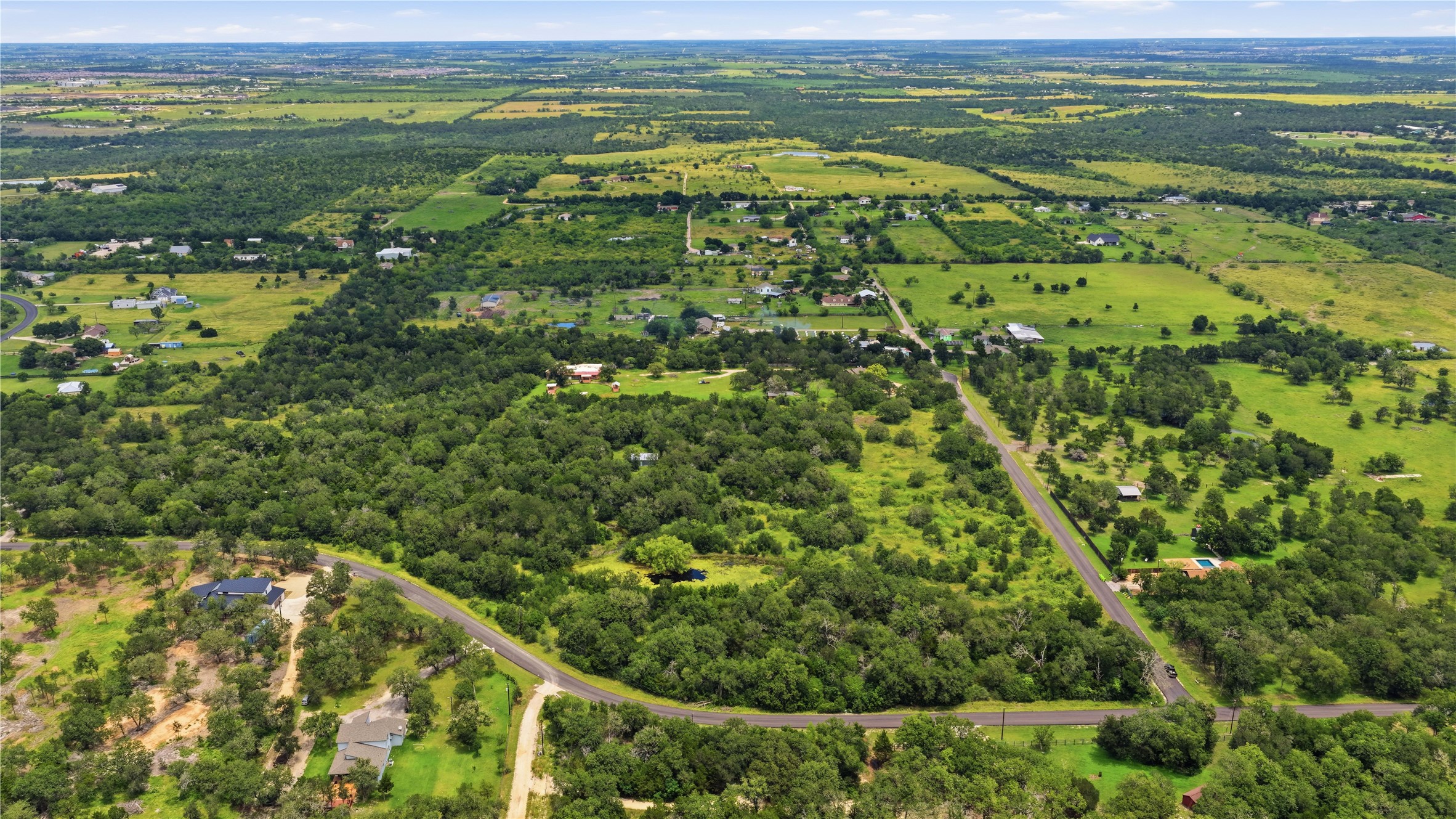 10312 Parsons Road Manor, TX 78653 - Photo 2 of 26 An aerial perspective reveals sprawling green landscapes and scattered homes, offering a peaceful countryside setting.