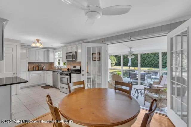 a living room with stainless steel appliances kitchen island granite countertop furniture and a large window