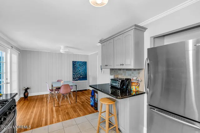 a kitchen with stainless steel appliances granite countertop a refrigerator a sink a stove and white cabinets