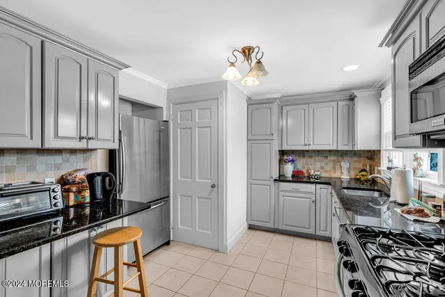 a kitchen with stainless steel appliances a stove a sink cabinets and a refrigerator