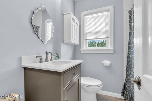 a bathroom with a toilet sink and mirror