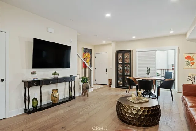 a living room with furniture a table and wooden floor