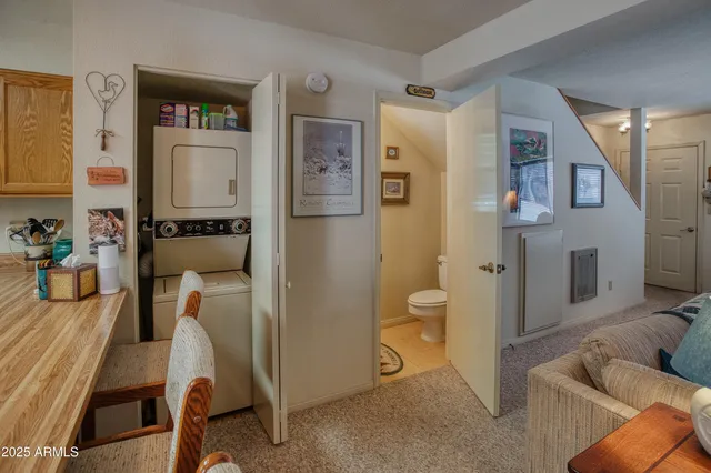 a kitchen with stainless steel appliances a refrigerator a stove a dining table and chairs with wooden floor