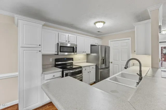 a kitchen with stainless steel appliances a microwave a sink and cabinets