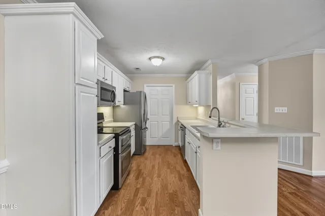 a kitchen with stainless steel appliances kitchen island a refrigerator sink and cabinets