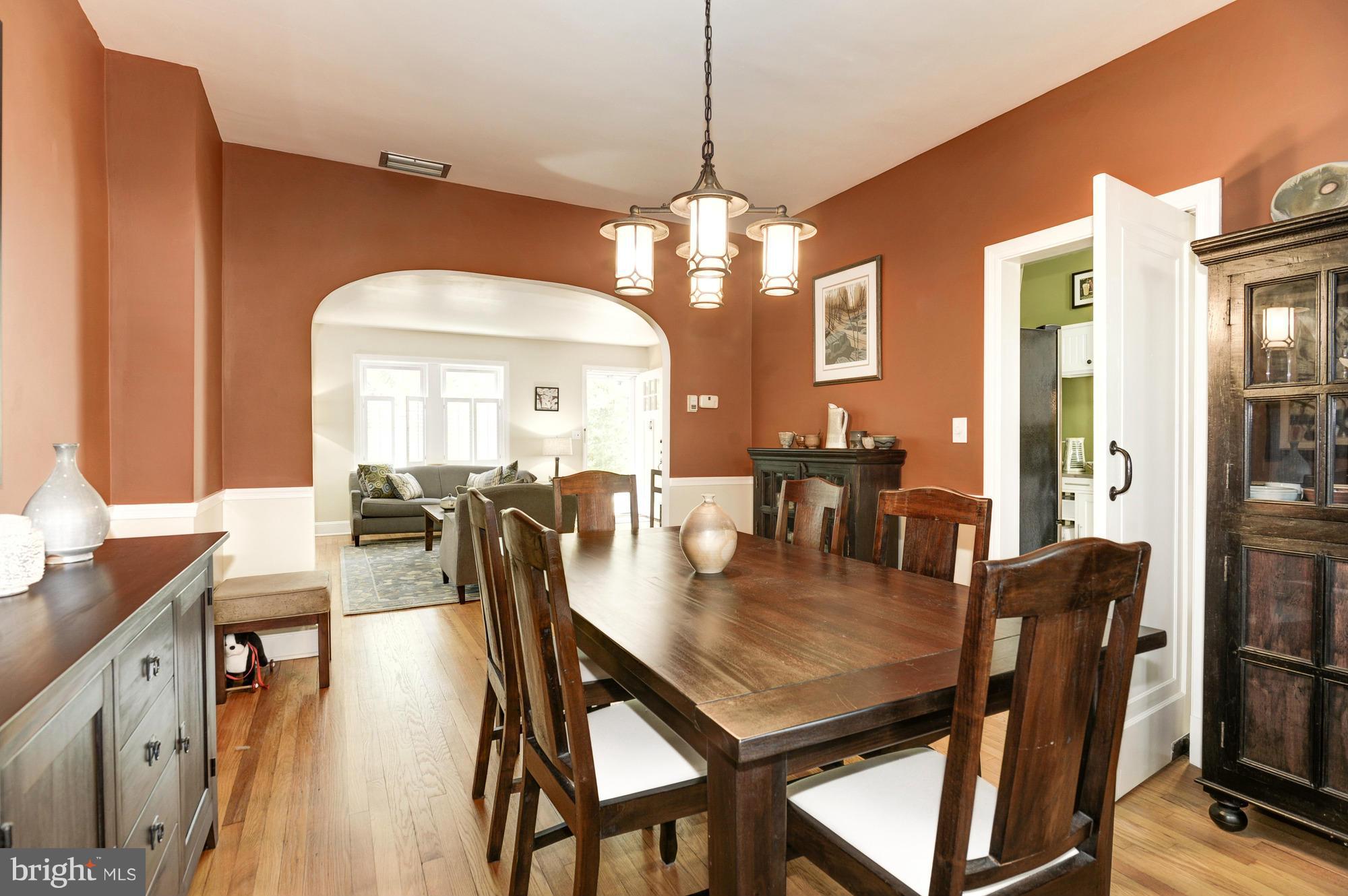 410 Hopkins Road Baltimore, MD 21212 - Photo 9 of 30 a dining room with wooden floor a chandelier a wooden table and chairs