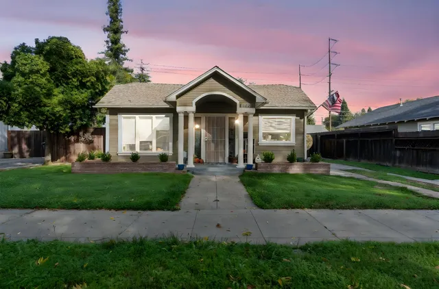 a front view of a house with yard and green space