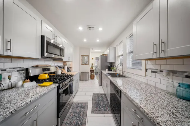 a kitchen with granite countertop stainless steel appliances and a counter space