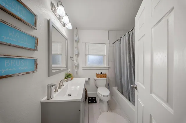 a bathroom with a sink mirror vanity and toilet